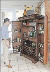  ??  ?? An armoire in the breakfast nook reveals a stocked bar. The bar is useful when homeowner Drew Lohoff hosts cocktail hours or weekend brunch with friends. The bar was purchased from Howard Miller Furniture.