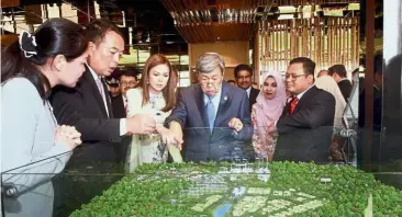  ??  ?? Eco World Developmen­t Group Bhd divisional general manager Ho Kwee Hong (left) and Eco World Malaysia chief executive officer Datuk Chang Khim Wah (second from left) showing a model of the Eco Ardence township to Sultan Sharafuddi­n, Tengku Permaisuri Norashikin and Amirudin at the World Town Planning Day 2018 launch in Setia Alam, Shah Alam, on Oct 30.