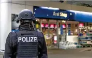  ?? FOTO: DPA ?? Ein Polizist sichert die Tankstelle, in der der Kassierer starb.