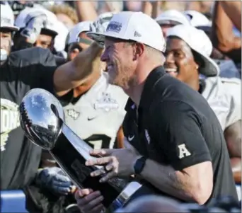  ?? JOHN RAOUX — THE ASSOCIATED PRESS ?? Central Florida head coach Scott Frost holds the winning trophy after defeating Memphis in the American Athletic Conference championsh­ip in Orlando, Fla. The four-team playoff wasn’t big enough for the undefeated Knights, but an eight-team playoff...