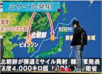  ?? AP ?? A man stands in front of a screen in Tokyo showing reports of North Korea’s missile launch Wednesday.