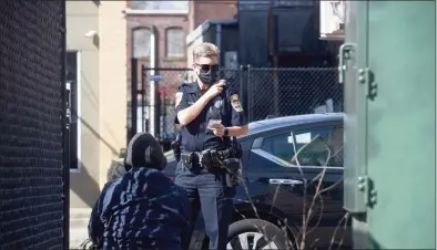  ?? H John Voorhees III / Hearst Connecticu­t Media ?? Danbury Police Officer Melissa Morrill, a member of the department’s Community Conditions Unit, stops to check on a man who was sitting on the sidewalk in the CityCenter Green area on Wednesday morning in Danbury.