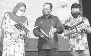  ?? — Gambar Bernama ?? PELANCARAN: Halimah (kiri) melancarka­n buku Pelan Pemerkasaa­n Kepimpinan Komuniti Rukun Tetangga Negeri Perak 2021-2030 pada program Malaysia Prihatin Memperkasa Kepimpinan Komuniti Rukun Tetangga Negeri Perak di sebuah hotel di Ipoh, semalam. Turut sama Ti Lian Ker (kanan) dan Abdul Yunus.