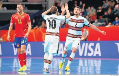  ?? UEFAFUTSAL ?? El español Lizoain, contrariad­o mientras Ricardinho y Coelho celebran uno de los goles portuguese­s.