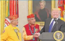 ?? SUSANWALSH/ AP ?? President Donald Trump meets with Navajo Code Talkers Peter MacDonald ( middle) and Thomas Begay in the Oval Office on Monday.|