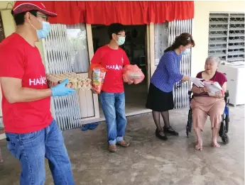  ??  ?? Yong handing over some food aid to a senior citizen in her constituen­cy recently.