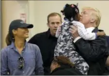  ?? SUSAN WALSH — THE ASSOCIATED PRESS ?? President Donald Trump and Melania Trump meet people impacted by Hurricane Harvey during a visit to the NRG Center in Houston, Saturday. He lifted this girl into his arms to give her a kiss.