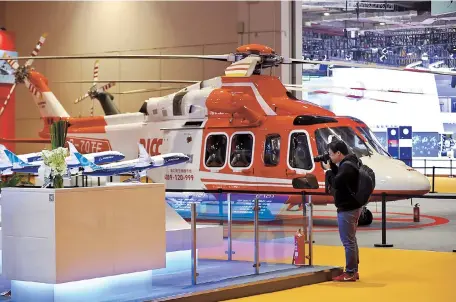  ??  ?? A helicopter and plane models are seen at the National Exhibition and Convention Center yesterday. Arrangemen­t of exhibits is nearly done at the venue of the China Internatio­nal Import Expo opening tomorrow. — Dong Jun