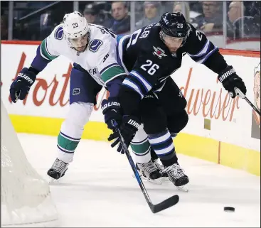  ?? THE CANADIAN PRESS ?? Vancouver’s Brandon Sutter (left) battles with Jets captain Blake Wheeler behind the Canucks net on Sunday. Winnipeg won 1-0 and sat in first place in the Central Division as of yesterday.