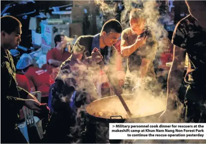  ??  ?? > Military personnel cook dinner for rescuers at the makeshift camp at Khun Nam Nang Non Forest Park to continue the rescue operation yesterday