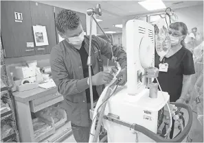  ??  ?? Respirator­y therapy team members assemble equipment in the Indiana University hospital stockpile of ready- to- use ventilator­s.
CHRIS BERGIN/ IU HEALTH BALL MEMORIAL HOSPITAL