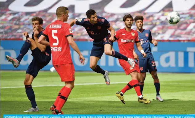  ?? — AFP ?? LEVERKUSEN: Bayern Munich’s Polish forward Robert Lewandowsk­i (C) heads to score his team’s fourth goal during the German first division Bundesliga football match Bayer 04 Leverkusen v FC Bayern Munich in Leverkusen, western Germany.