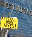  ?? MATTHEWHEN­DRICKSON/ SUN- TIMES ?? A protester holds a sign across the river fromTrump Internatio­nal Hotel and Tower on Saturday.