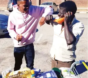  ??  ?? King 98 (left) hands over groceries worth $10 000 to Patrick Mkwamba