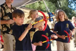  ?? Ryan Mancini/The Signal (See additional photos at signalscv.com) ?? From left, Cub Scouts Draedyn Stacey, Ryker Reagan and Jackson Via participat­e in an archery lesson while at the Cub Scout Pack 490’s recruitmen­t barbecue at Hart Park on Saturday.