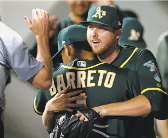  ?? Ted S. Warren / Associated Press ?? A’s starter Paul Blackburn (right) gets a hug from infielder Franklin Barreto after Blackburn is pulled from the game after 72⁄3 innings of one-run ball in his second big-league start.