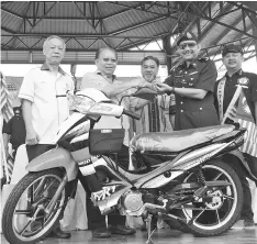  ??  ?? Pairin handing over a motorcycle to Ahmad. Also seen are Jake (right),Yusop (third right) and Raymond (left).