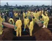  ?? MANIKA KAMARA — THE ASSOCIATED PRESS FILE ?? FILE- In this Thursday file photo, volunteers handle a coffin during a mass funeral for victims of heavy flooding and mudslides in Regent at a cemetery in Freetown, Sierra Leone.