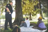  ??  ?? Lodi Police Community Liaison Officer Ryan Holz chats with Amber Smith and Gabriel Chavez about resources that may be available to them in Lodi on Friday morning.