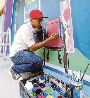  ??  ?? Man at work: Abdul Rahman busy painting the wall of Sekolah Agama Dato Onn Jaafar, Larkin.