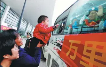  ?? YUAN XIAOQIANG / FOR CHINA DAILY ?? A 1-year-old boy is lifted by his grandmothe­r on Wednesday to greet his arriving father, Zhang Ding (in window), as the boy’s mother, Gu Jie (far left), looks on at Zhengzhou Xinzheng Internatio­nal Airport in Henan province. Zhang was returning from a yearlong United Nations peacekeepi­ng mission in South Sudan. The boy was born just as Zhang, a member of China’s fourth peacekeepi­ng infantry battalion, headed out for the mission.