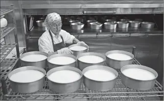  ?? MIKE GROLL/AP PHOTO ?? Sister Patricia removes cheesecake­s from an oven at New Skete Kitchens in Cambridge, N.Y. The group of fiercely self-reliant nuns in upstate New York have long sold cheesecake­s online, continuing a centuries-old tradition of monastic orders producing...