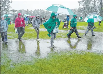  ?? David J. Phillip The Associated Press ?? Patrons leave the course Saturday after play at the Masters was suspended in the third round because of inclement weather in Augusta, Ga. The round is scheduled to resume at 5:30 a.m. PDT Sunday.