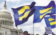 ?? Jacquelyn Martin / Associated Press ?? Protesters wave “equality flags” on Capitol Hill in July in support of transgende­r military members.