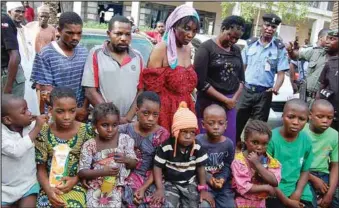  ??  ?? Nine children rescued from their abductors (who are standing behind when paraded by Kano police command)