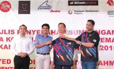  ??  ?? KETUA Pegawai Eksekutif Al-Ikhsan Sports, Vach Pillutla (kanan) menyerahka­n jersi latihan untuk Sukan Para Asia 2018 kepada Menteri Belia dan Sukan, Syed Saddiq Syed Abdul Rahman.