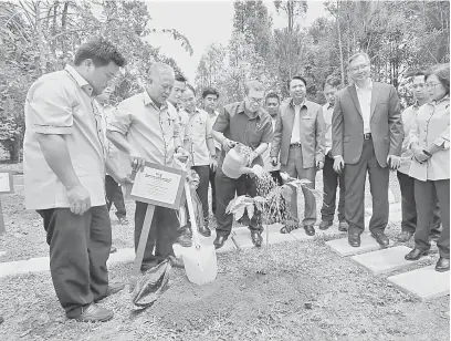  ??  ?? SIMBOLIK: Anthoney menanam pokok di pekarangan pejabat RDID selepas majlis perasmian. Turut kelihatan Hamden (depan, tiga kanan) dan Wan Lizozman (empat kiri).