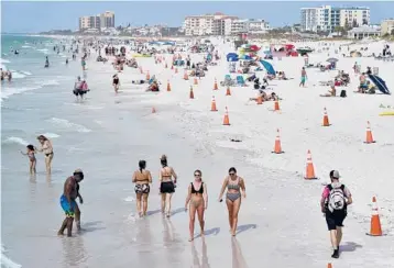  ?? CHRIS O’MEARA/AP ?? Beachgoers enjoy their time last week in Clearwater a popular spring break destinatio­n, west of Tampa. Colleges around the country are scaling back or canceling spring break to discourage partying amid the pandemic.