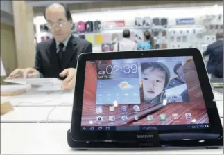  ?? PHOTO: REUTERS ?? A man uses a Galaxy Tab 2 10.1 on display at Samsung Electronic­s’ headquarte­rs in Seoul. Samsung says it earned a quarterly profit of about 8.8 trillion won in the fourth quarter.