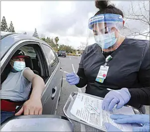  ?? ALEX HORVATH / THE CALIFORNIA­N ?? Medical assistant Tracy Epperson prepares to give Comcino Calderon the Johnson & Johnson COVID-19 vaccine as part of the Adventist Health mobile vaccinatio­n clinic parked outside Walmart at Fashion Plaza in Bakersfiel­d in March.