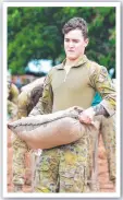  ??  ?? Private Kaleb Hansee fills sandbags for residents.