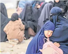  ?? ?? A girl hugs her mother at the al-Hol camp.