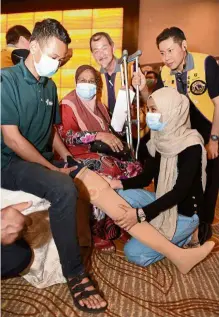  ?? — KT GOH/The Star ?? Dream come true: Afiq looking at his new prosthetic limb presented to him during the Prosthetic Limb, Wheelchair and Hearing Aid Project presentati­on ceremony at a hotel in George Town, Penang.