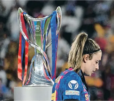  ?? ?? Una decepciona­da Alexia Putellas, junto al trofeo que se llevó el Olympique de Lyon