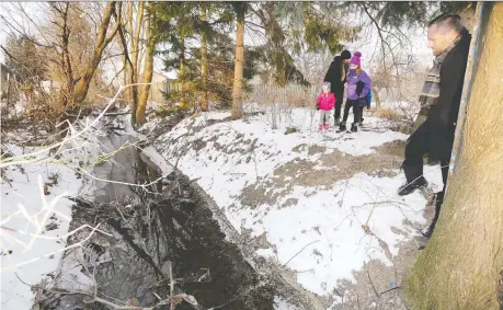  ?? NICK BRANCACCIO ?? Shawn Maheux, right, his wife Katie and their three kids walk past the Cahill drain behind their Bouffard Road home Wednesday. Lasalle town officials informed the family by letter in July they would need the property to improve drainage in the municipali­ty as part of its master plan.