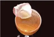  ??  ?? The Rosicrucia­n is prepared with cognac, rose liqueur, pink champagne and lemon juice. Bee’s wax and labdanum are added to the bowl of a floating rose petal.