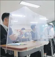  ?? AFP ?? ■
Students sit behind protective shields in a classroom in Daejeon, South Korea.