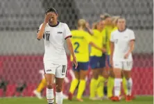  ?? Ricardo Mazalan / Associated Press ?? U.S. forward Christen Press seems in disbelief after Sweden players celebrates their third goal Wednesday in Tokyo.