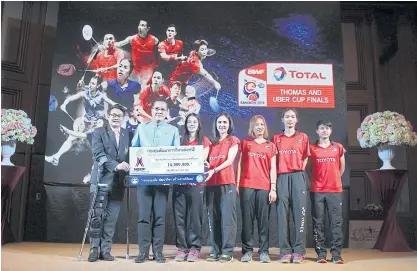  ??  ?? Thai Uber Cup players receive a cash bonus from Tourism and Sports Minister Weerasak Kowsurat, second left.
