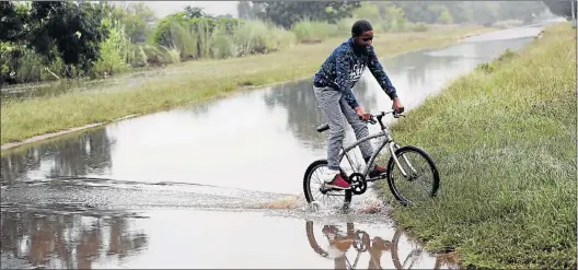  ?? Picture: JACKIE CLAUSEN ?? CALM AFTER THE STORM: Jojo Morgan, 14, crosses a flooded street in Newcastle