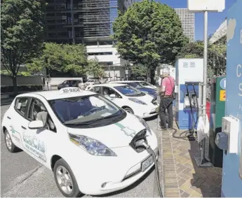  ?? DON RYAN/AP FILE ?? Cars at charging stations in front of the Portland General Electric headquarte­rs building.