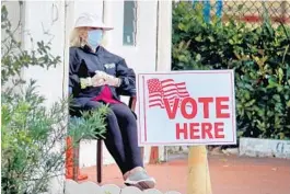  ?? SUSAN STOCKER/SOUTH FLORIDA SUN SENTINEL ?? A poll worker at the First Baptist Church voting site in Hollywood wears a protective mask and gloves during Florida’s presidenti­al primary voting on March 17.