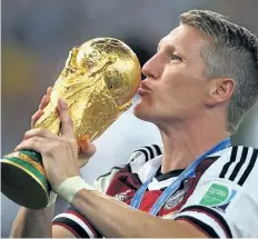  ?? GETTY IMAGES FILE ?? Bastian Schweinste­iger of Germany kisses the World Cup trophy after defeating Argentina in 2014 FIFA World Cup. Schweinste­iger announced Friday he was leaving internatio­nal play.