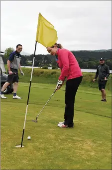  ?? Photo by Michelle Cooper Galvin ?? Angela Brosnan putting out in the Kenmare Golf Club fundraisin­g golf marathon with Padraig Barry and John Duggan at the venue on Friday.