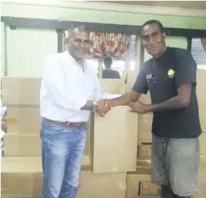  ?? Photo: Arieta Vakasukawa­qa ?? Acting Prime Minister and Minister for Industry, Trade, Tourism, Lands and Mineral Resources Faiyaz Koya with Votua Village headman, Simione Navara in Ba distributi­ng boxes of clothes and bottled water on May 5, 2018.