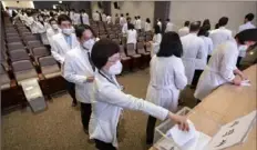  ?? Yoon Dong-jin/Yonhap via AP ?? Medical professors queue to submit their resignatio­ns Monday during a meeting at Korea University in Seoul, South Korea.